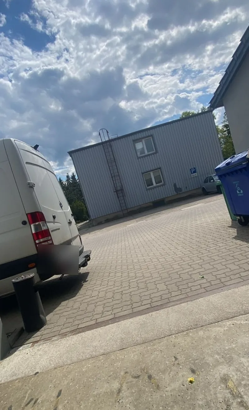 Weißer Sprinter von hinten auf dem Hof vor einer Lagerhalle