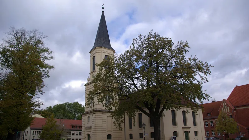 Dreifaltigkeitskirche in Zossen mit großem Baum davor